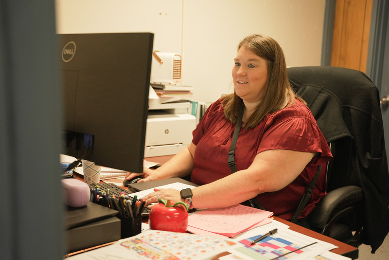 principal sitting at computer working on a project