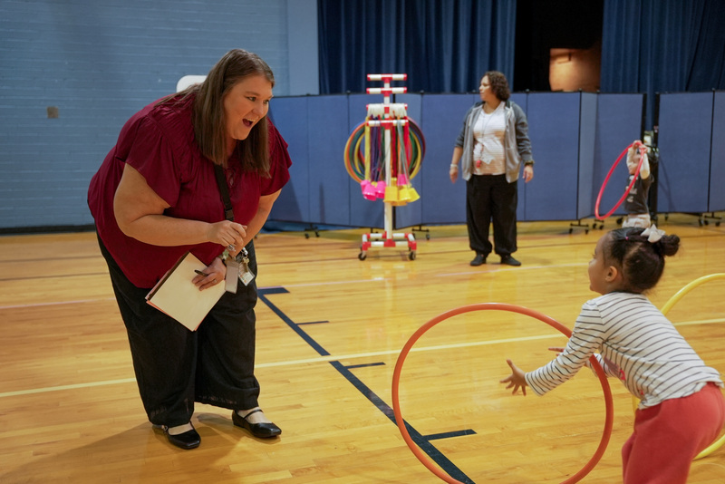 principal playing with little girl in gym