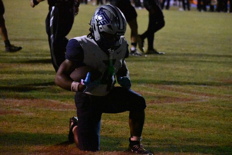 #4 kneels for a prayer after touchdown
