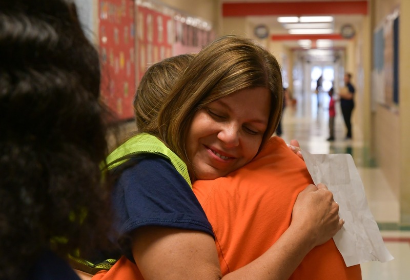 Principal Oceguera hugging the recipient of a TIA award