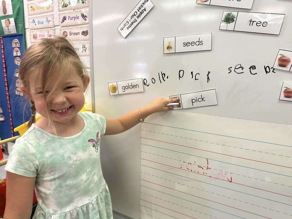 Student pointing to the word pick on the board