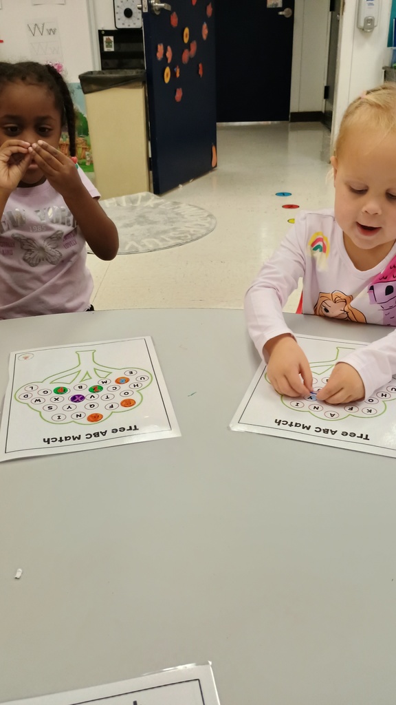 PreK students with worksheets pasting circles