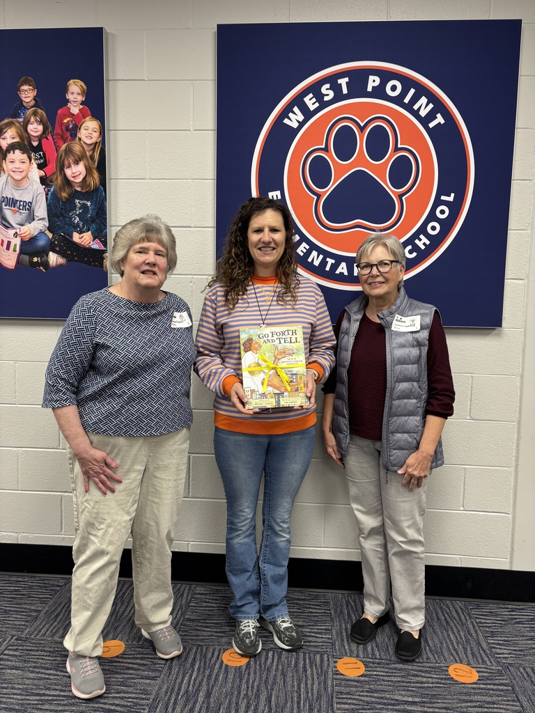 Ms. Milby and Ms. Bray donate a book to WPES Librarian C. Long in memory of WPES Librarian Barbara Firesheets