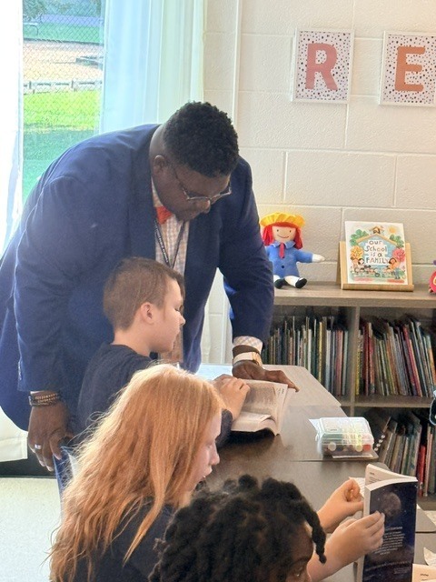 Dr. Frazier looking at a students new dictionary from West Point Rotary