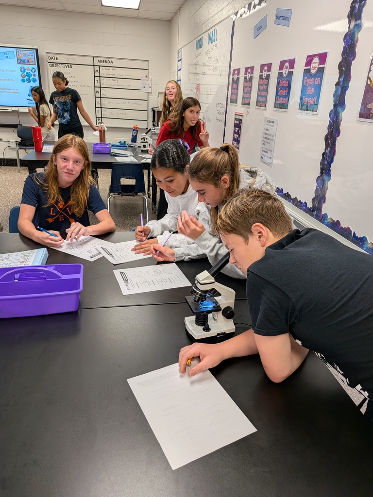 Life Science students in Mrs. Tate’s class examine microscope slides to determine whether samples were once living and contained cells.