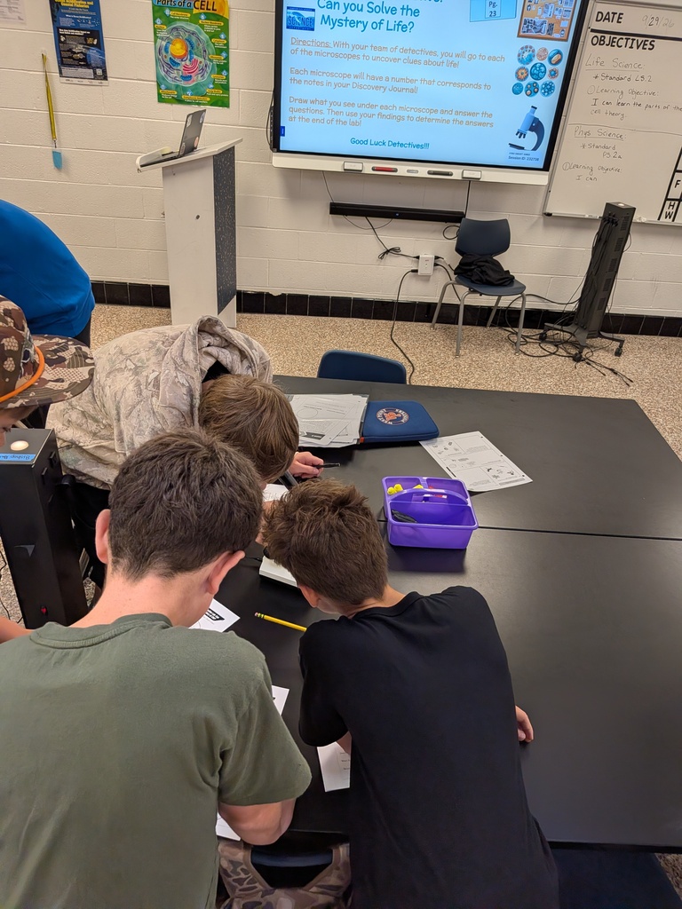 Life Science students in Mrs. Tate’s class examine microscope slides to determine whether samples were once living and contained cells.