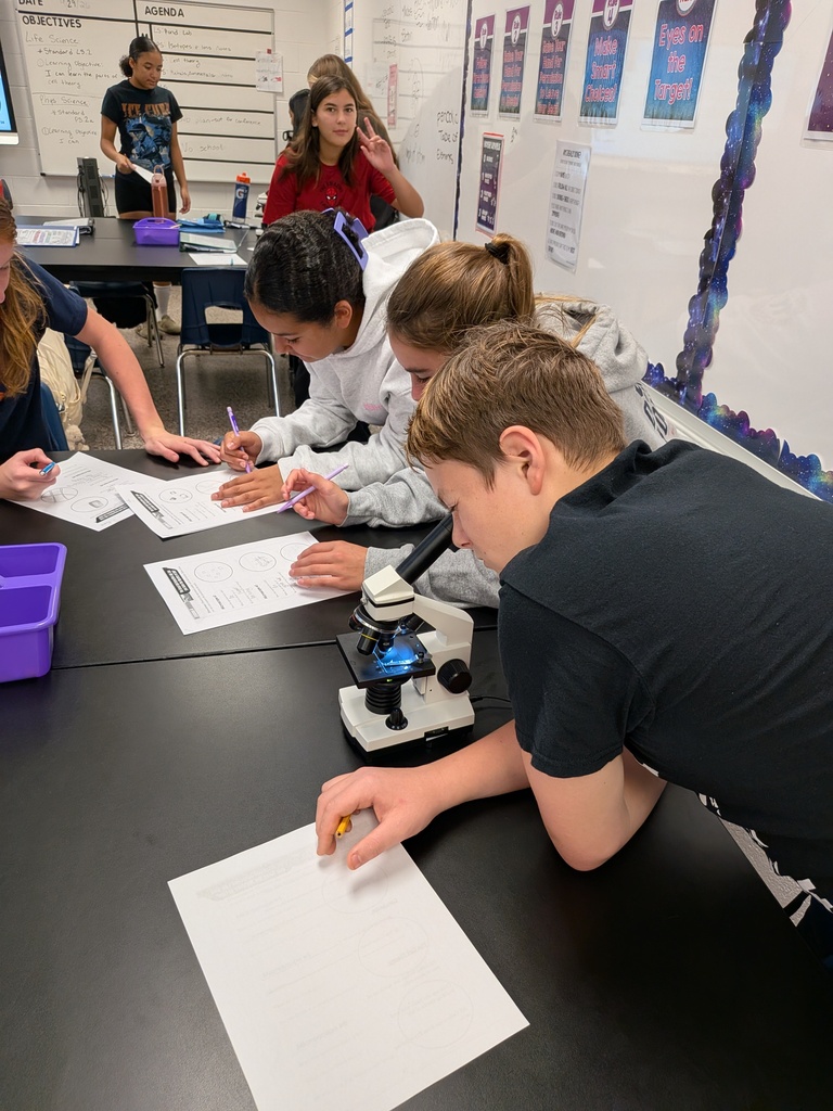 Life Science students in Mrs. Tate’s class examine microscope slides to determine whether samples were once living and contained cells.