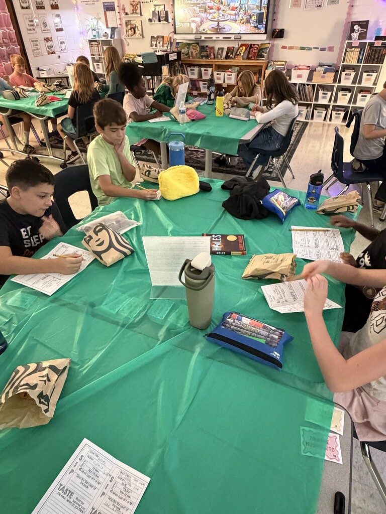 Fifth-grade students participate in Starbucks-themed learning activities, including a book tasting, stem-and-leaf data challenge, coffee bean estimation, and place value games, while enjoying themed snacks and drinks.