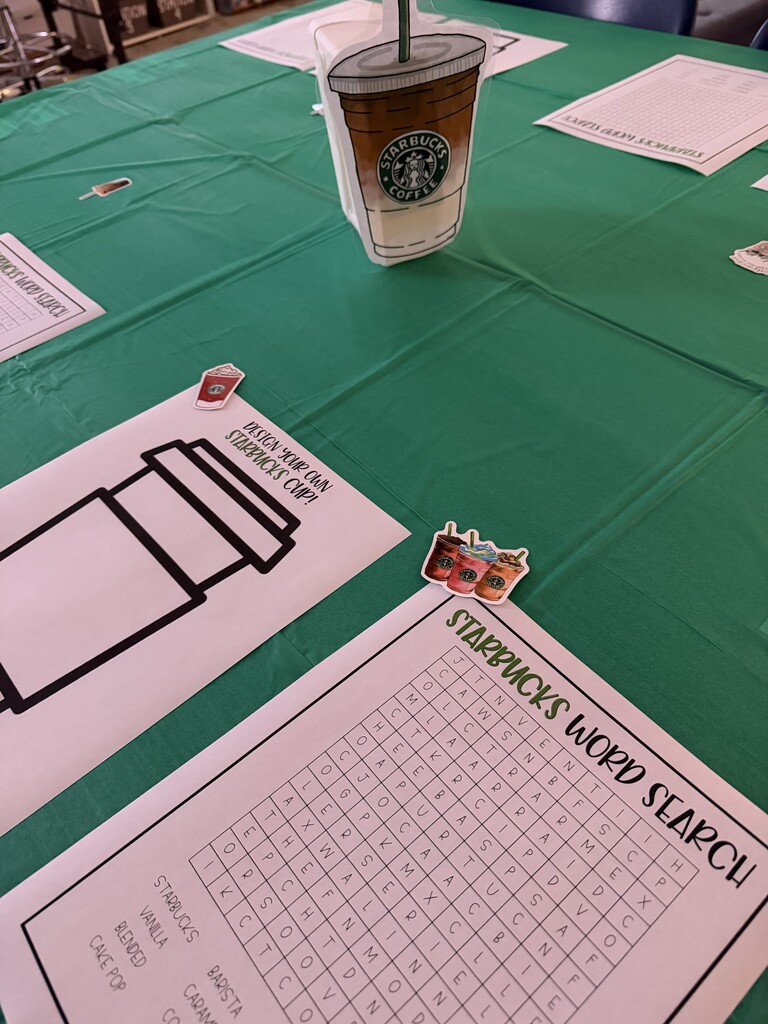 Fifth-grade students participate in Starbucks-themed learning activities, including a book tasting, stem-and-leaf data challenge, coffee bean estimation, and place value games, while enjoying themed snacks and drinks.