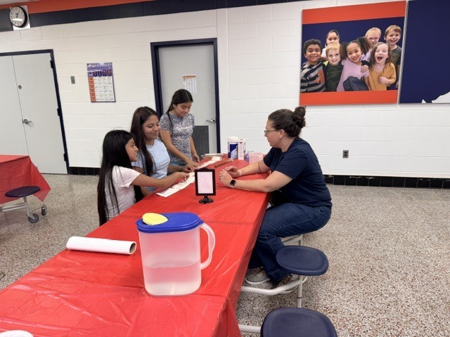 ELL students and their families enjoy a welcome-back cookout while students participate in five hands-on science activities hosted by the ELL Family Engagement Committee.