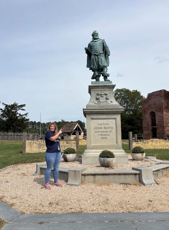 Mrs. Romero standing and pointing at the statue of John Smith at Historic Jamestown
