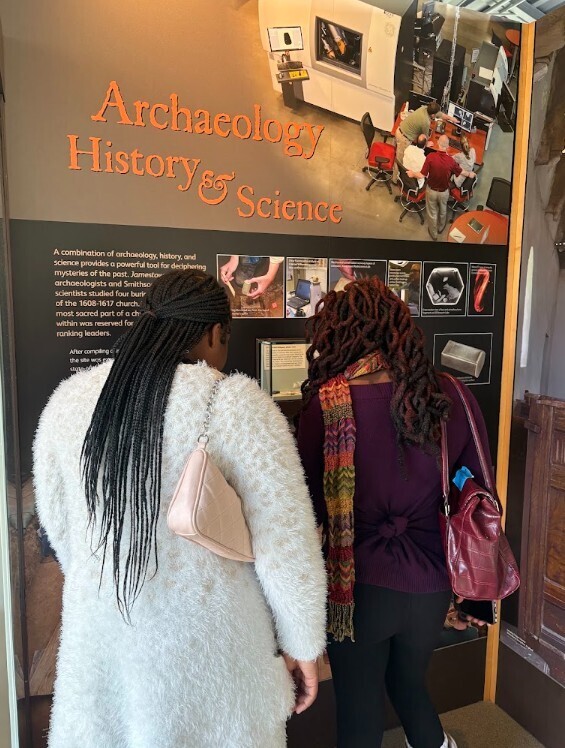 2 students standing, looking and reading about the Archaeology History and Science at Historic Jamestown
