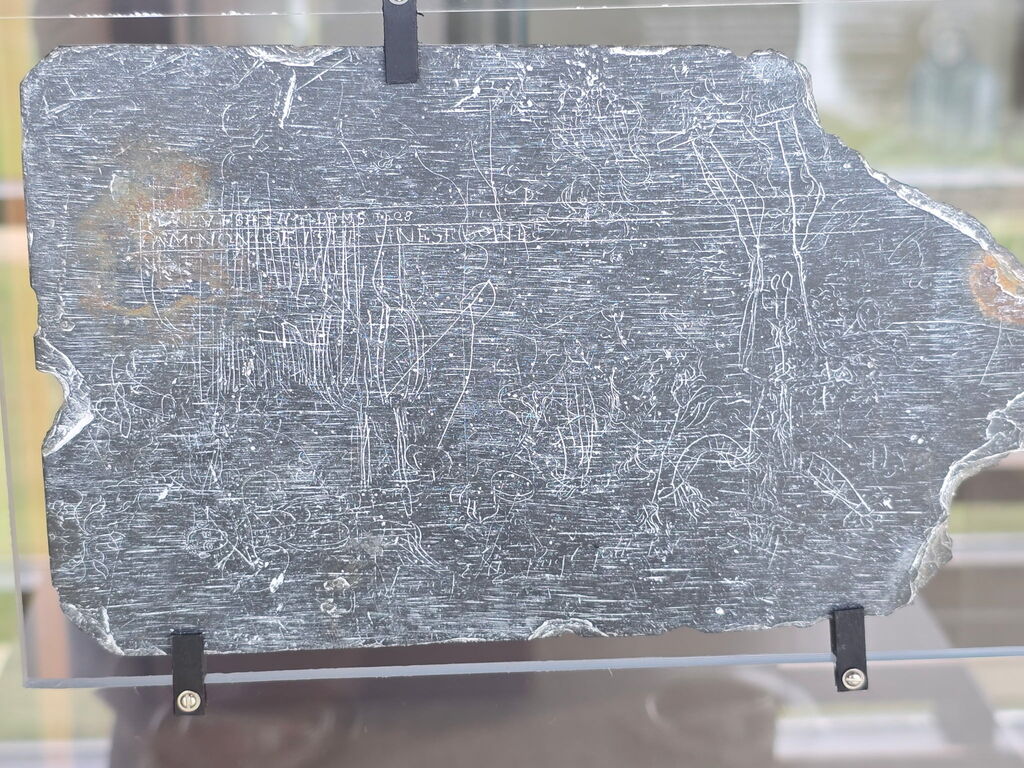 An artifact from the Jamestown Settlement, appears to be a slate with some inscriptions