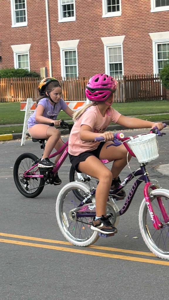 Young Pointer students ride their bicycles during the Tour de Crab community event, smiling and enjoying the ride.