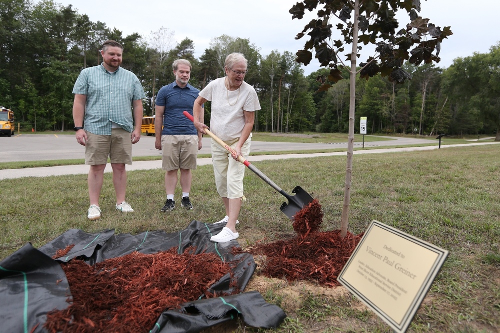 3 people putting wood chips on a newly planted tree