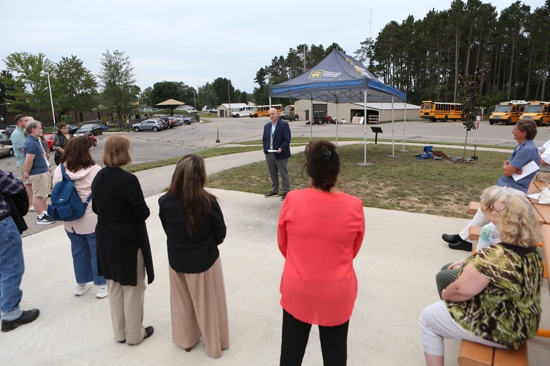 Dr. Jason Jeffery talking to crowd in front of tree.