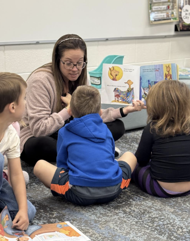 Teacher reading a book to students