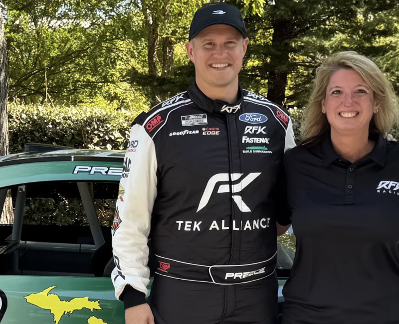 NASCAR driver Ryan Preece and Katina Moris standing in front of his race car.