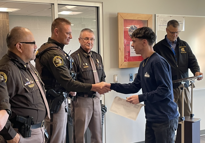 Student receiving an award from the a police officer.