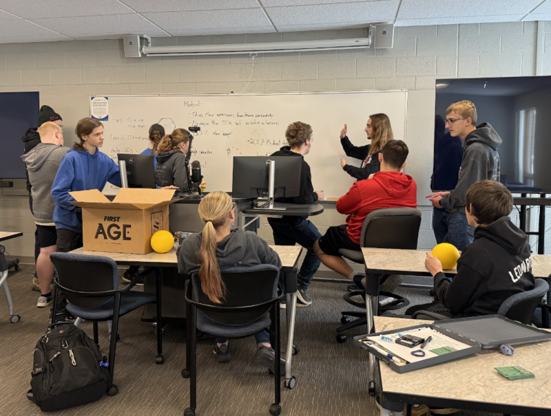 Students working on a project using a white board
