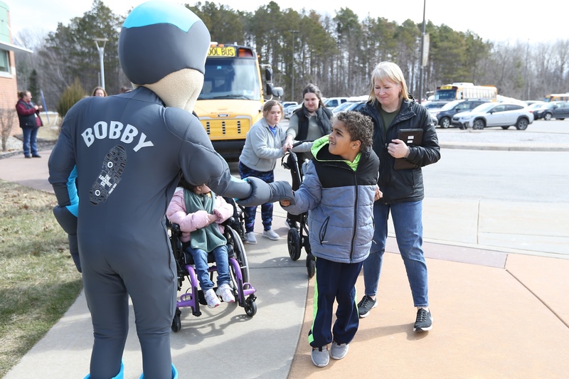 A mascot greeting students