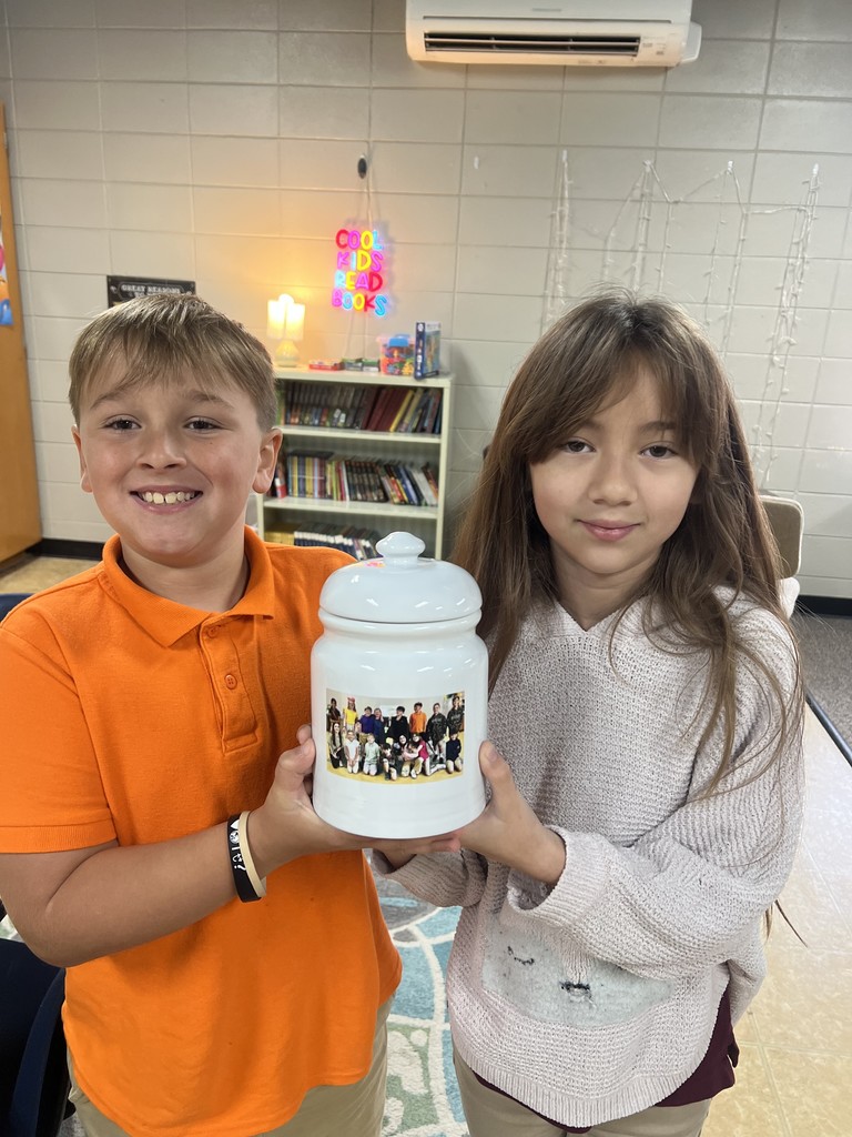 4th graders holding the cooking jar they made for their auction project