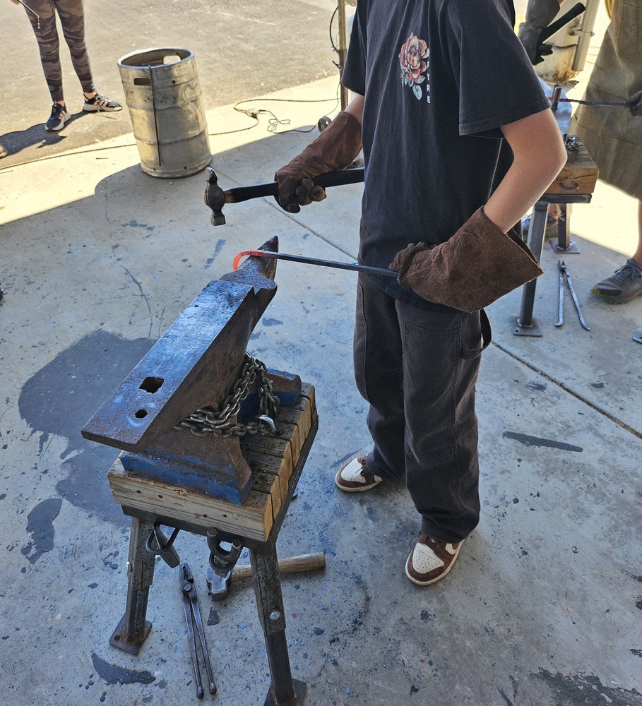 Student learning to blacksmith