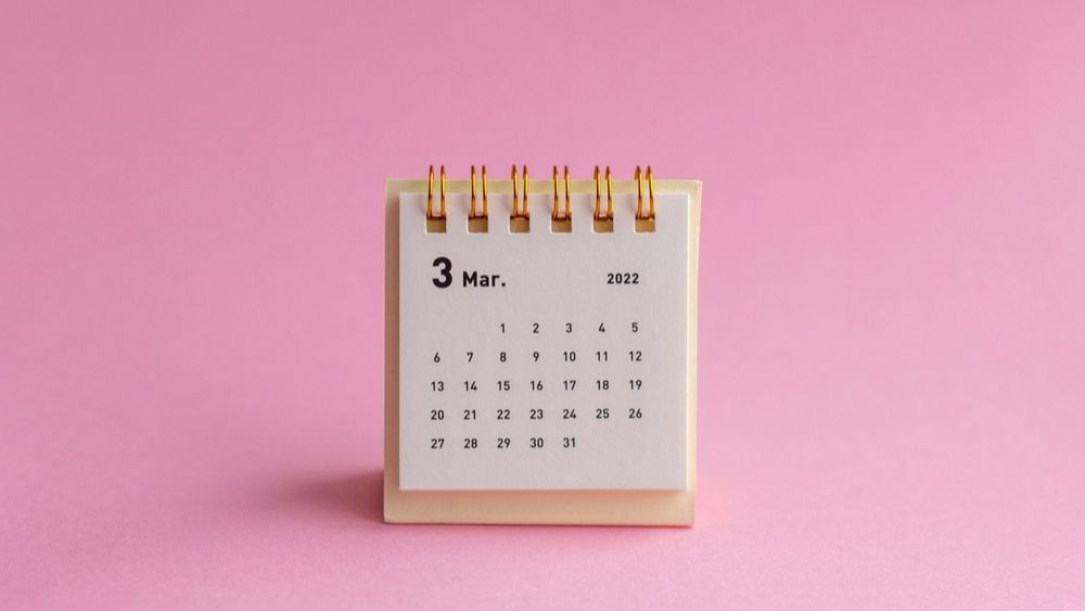A desk calendar on a pick background