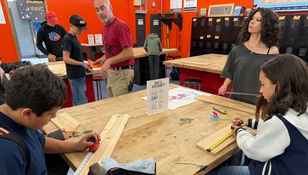 Image of students wood working at a table in the wood shop