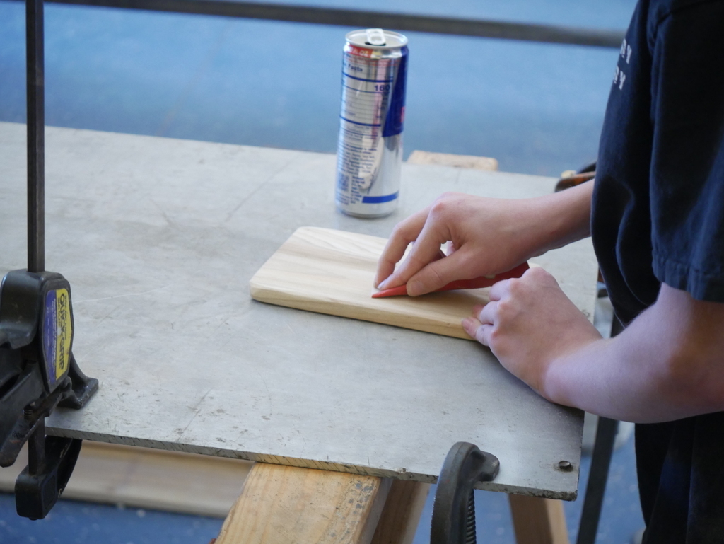 Student sanding wood for laser cutting