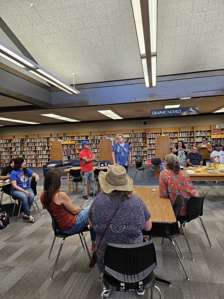 Staff in the library listening to Librarian, Julie McClelland, speak