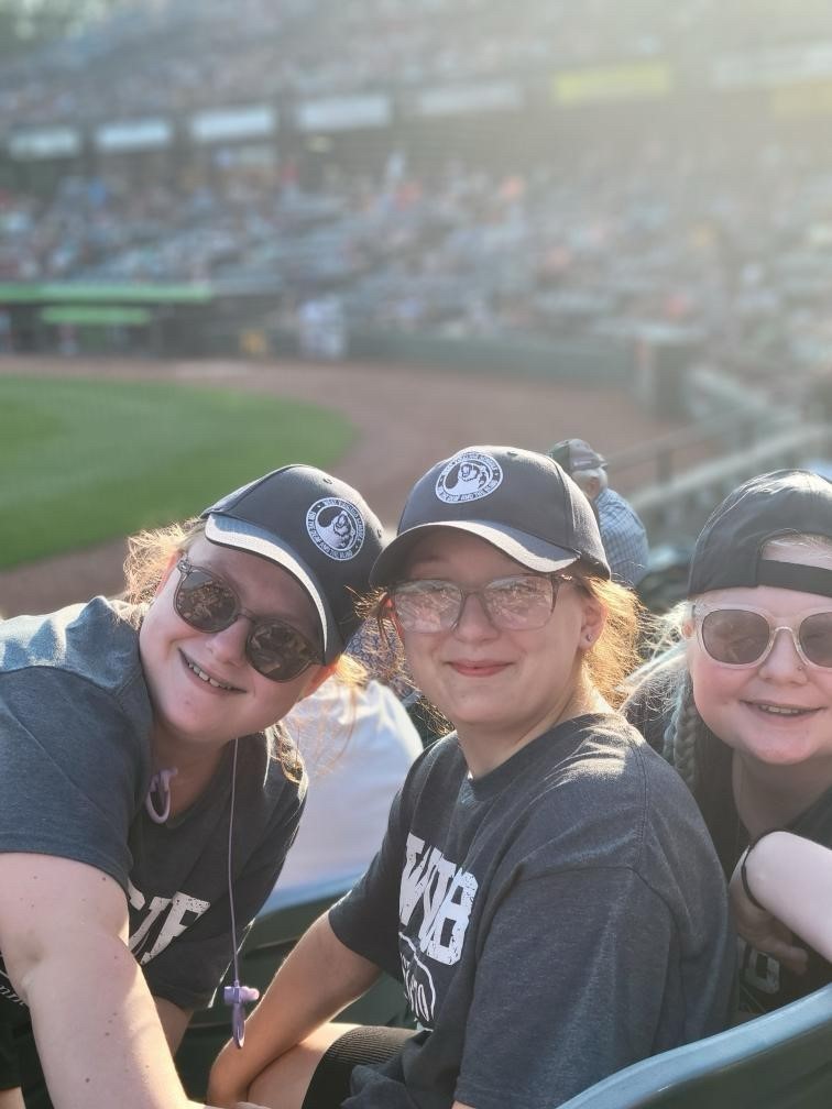Three female camp participants pose and smile for the camera. 