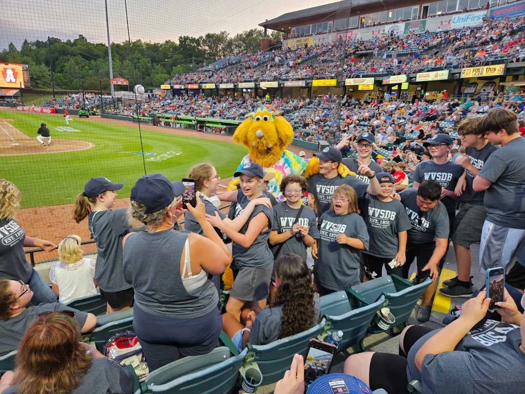 Camp participants getting a group photo with one of the yellow mascots. 