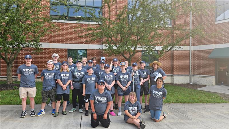 A group photo of camp participants standing side-by-side one another. 