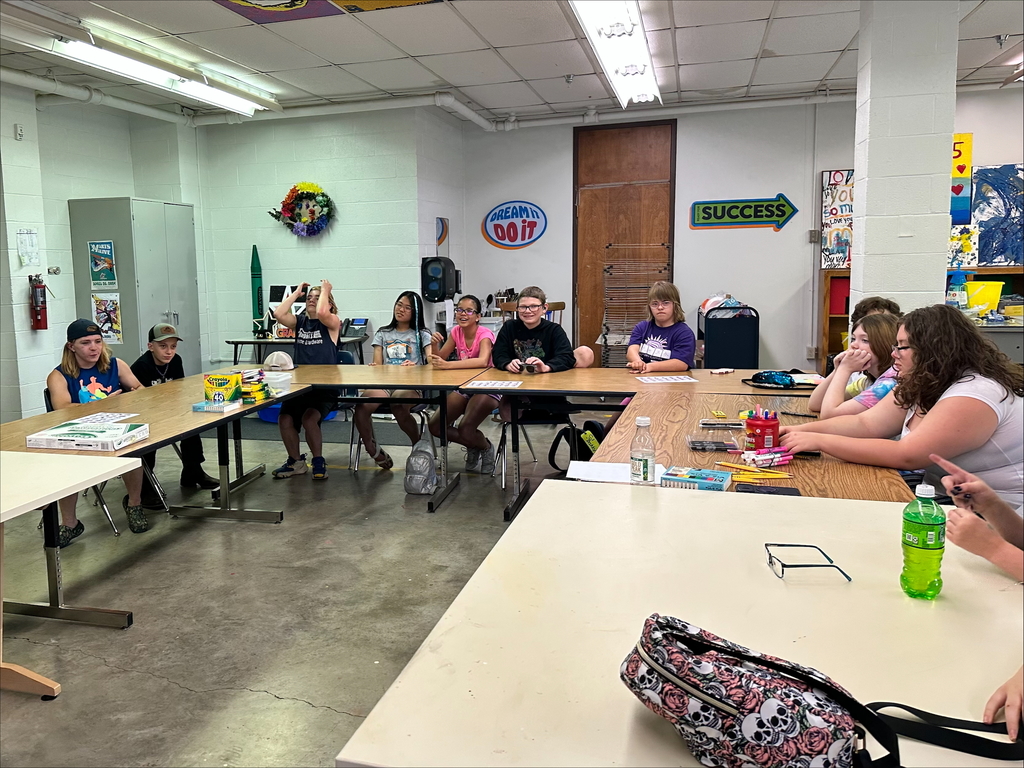 Camp participants seated at a table waiting for directions during their ASL activity. 