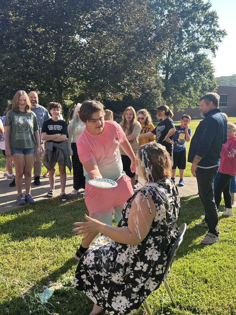 A male student gets ready to smear a plate of pie in Mrs. Hesse's face.