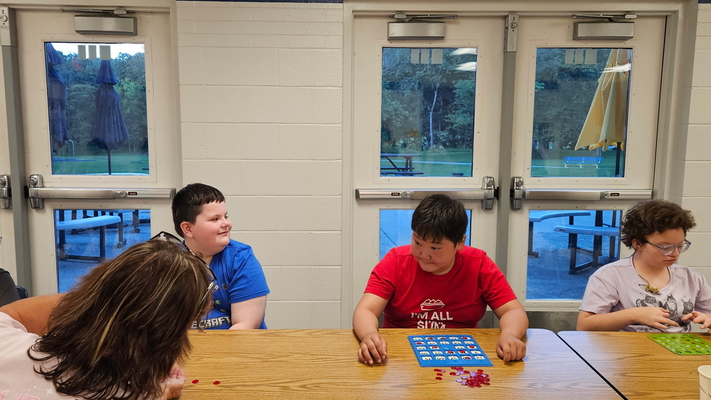 Students seated at a rectangular-shaped table playing an array of games.