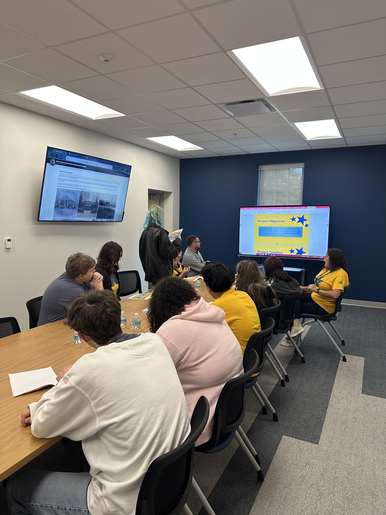 Students gathered around a conference table during their presentation.