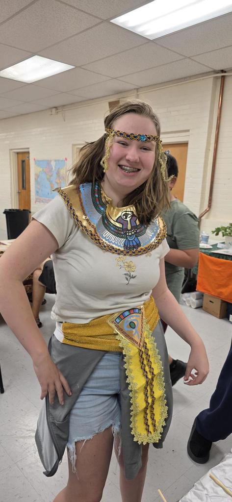 A female student smiles at the camera as she wears Egyptian attire.