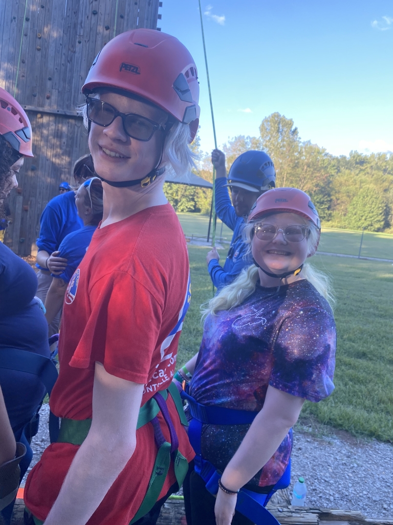 Two students smile for the camera as they prepare to participate in the rock-climbing activity.