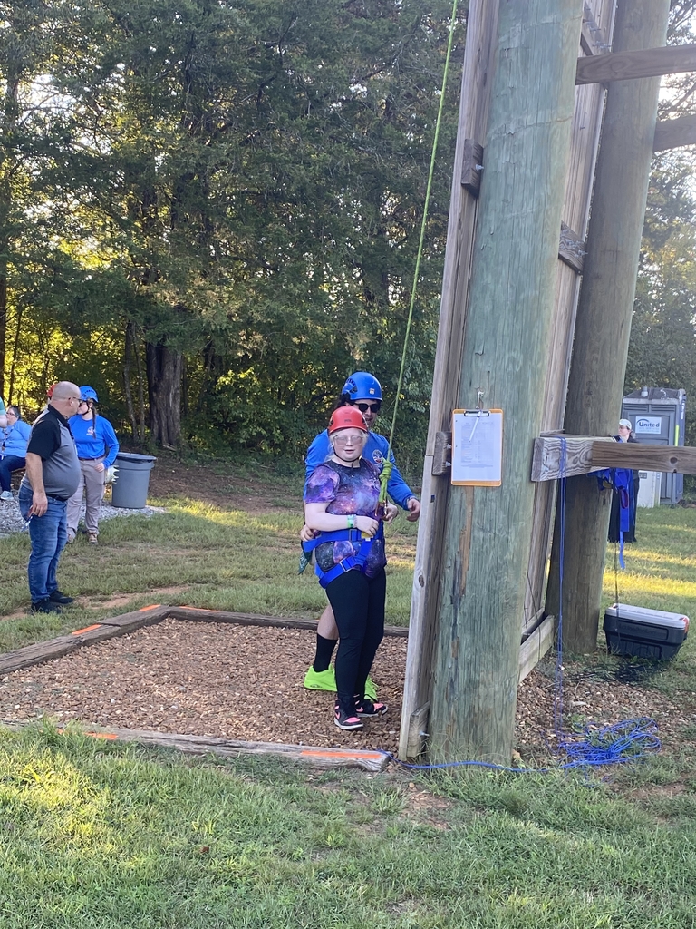 A female student prepares to begin the rock-climbing activity.