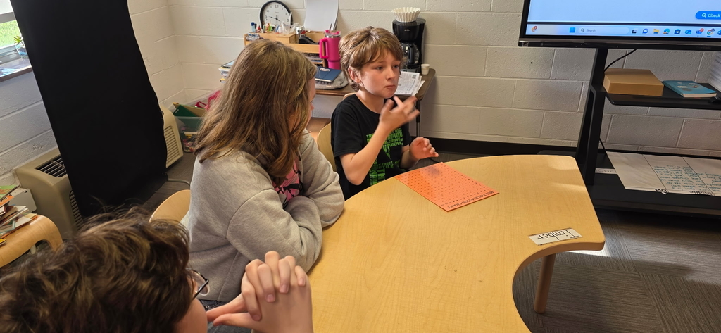 A male student signs using American Sign Language (ASL) while students observe him.