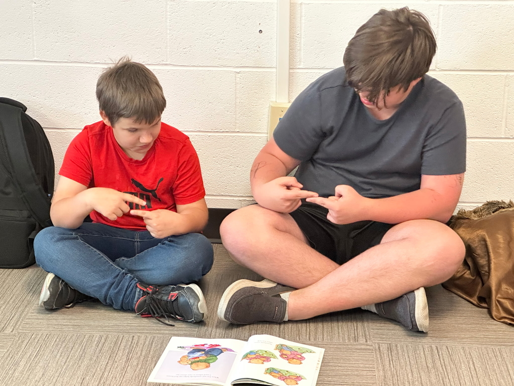 Two male students sit side-by-side as they practice math.