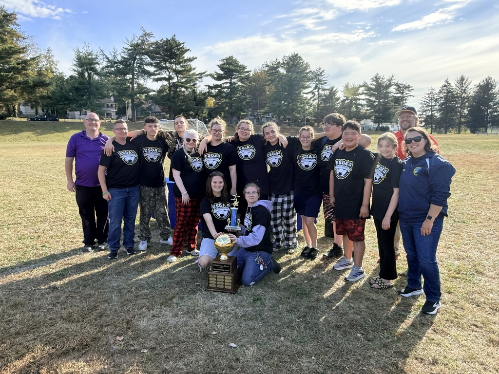 Group photo of the WVSDB soccer team and coaches posing with the Sportsmanship Award trophy.