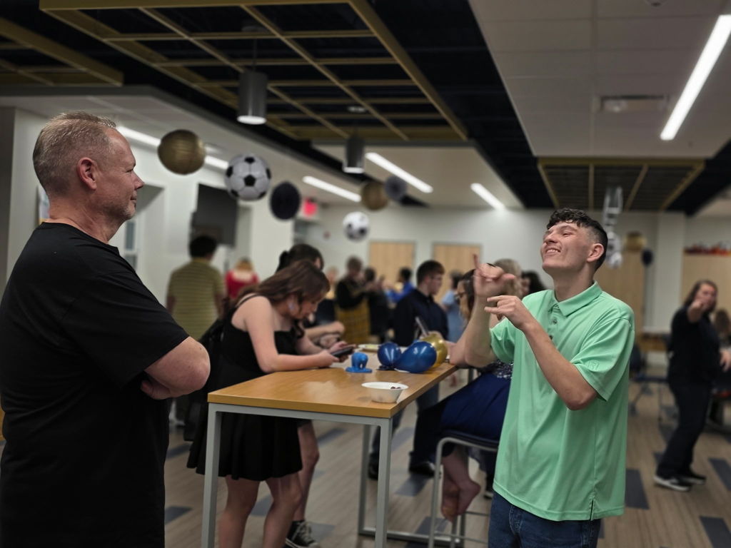 A male student socializes using American Sign Language (ASL).