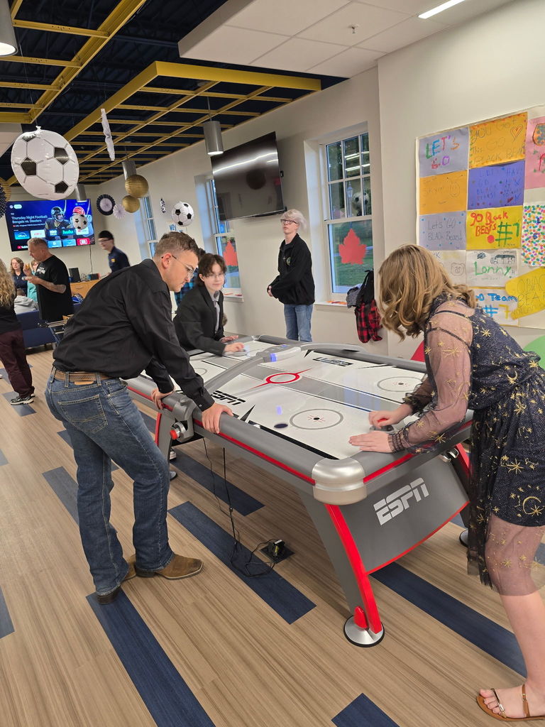Students playing a game of air hockey.