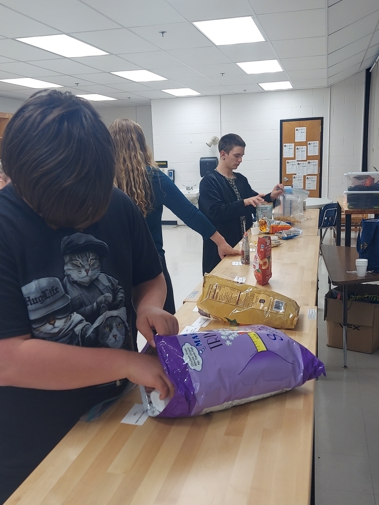 Two students put together their trail mix snacks.