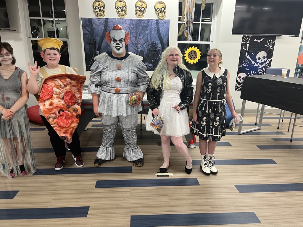Students dressed in their Halloween costumes stand side-by-side.