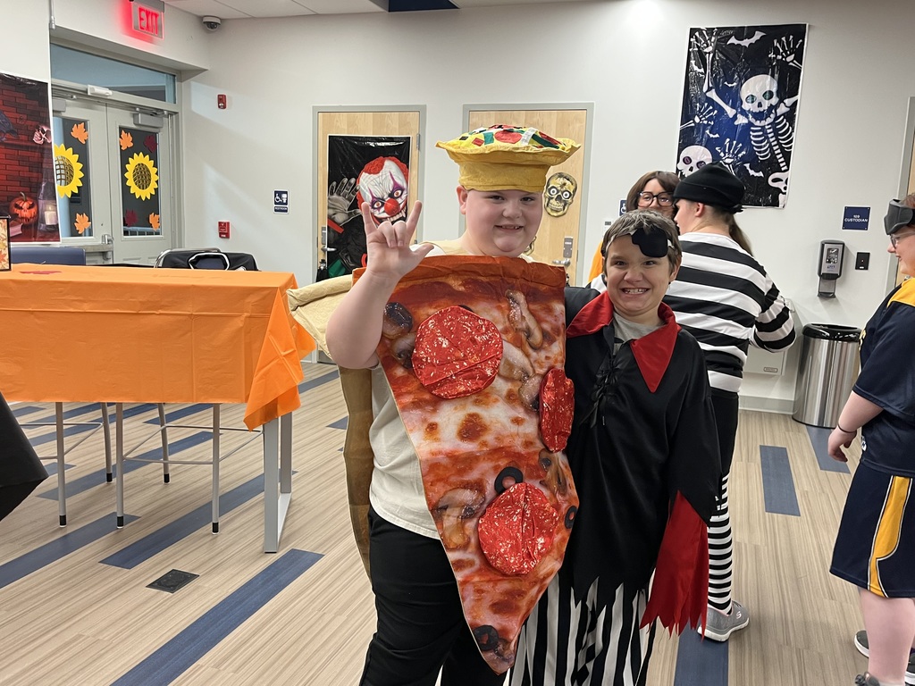 Two male students stand side-by-side in their Halloween costumes.