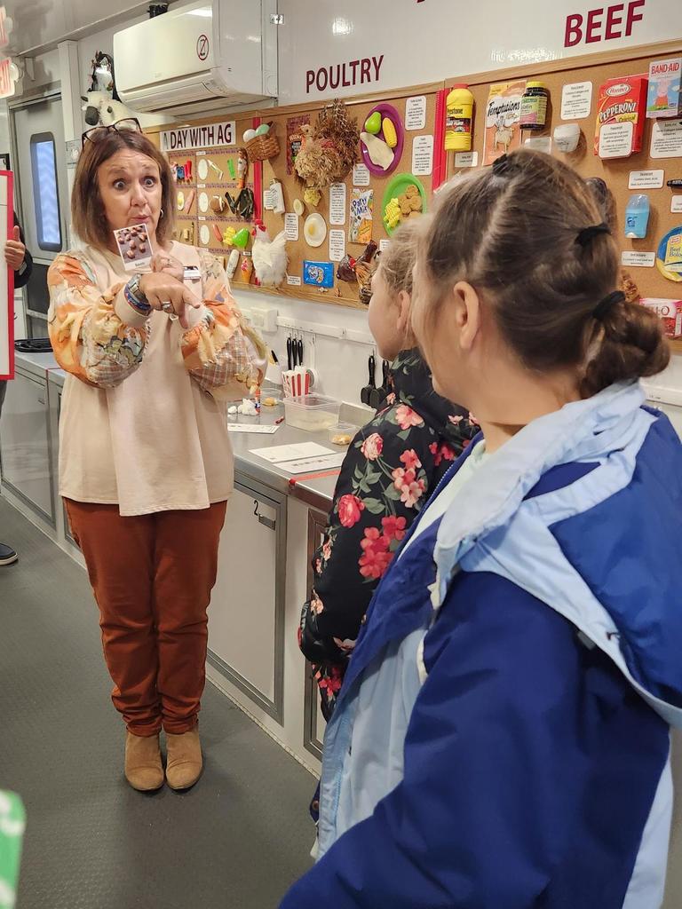 Students observe a female discuss the mobile science lab activities.